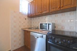 eine Küche mit Spüle, Mikrowelle und Geschirrspüler in der Unterkunft Studio für 4 Personen ca 48 qm in Fažana, Istrien Istrische Riviera in Fažana + 14 Fotos