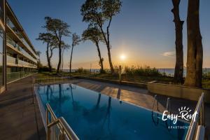 a swimming pool with a view of the ocean at Blue BIEN Easy - Rent Apartments z widokiem na morze in Rewal