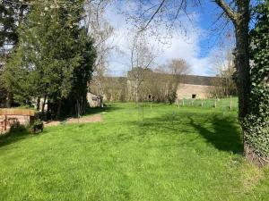 a field of grass with trees and a fence at Gîte au cœur de la Suisse Normande in Clécy