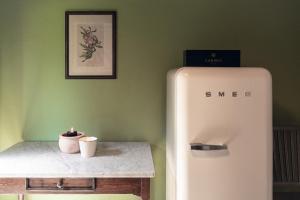 a white refrigerator next to a table with a candle at Bolgheri Countryhouse in Bolgheri