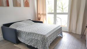 um quarto com uma cama com um cobertor preto e branco em Agréable 2 pièces à Savigny sur Orge em Savigny-sur-Orge