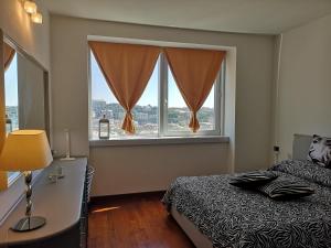 ein Schlafzimmer mit einem Bett und einem großen Fenster in der Unterkunft Suite Lambruschini central with top city view - Free covered parking in Genua