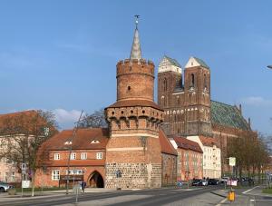 een groot bakstenen gebouw met een toren en een kerk bij Komplette Wohnung nahe am See in Prenzlau