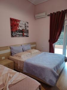 a bedroom with two beds and a painting on the wall at Apartment Eclipse in Sarandë