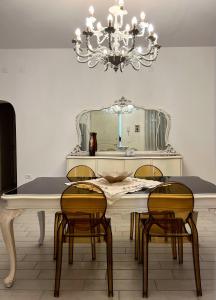 a dining room with a table with chairs and a chandelier at Casa Bianca Soave in Soave