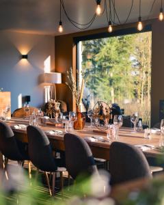 a long wooden table with chairs and a large window at Le Domaine de Bra in Bra