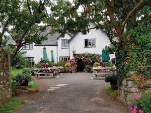 a building with tables and umbrellas in front of it at 3 Bed in Bude 57739 in Morwenstow