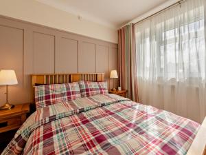 a bedroom with a bed with a plaid blanket and a window at 2 Bed in Saundersfoot 94207 in Saundersfoot