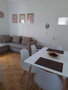 sala de estar con mesa blanca y sillas en Cosy seaside house at Lagkada Chios, en Lagkáda