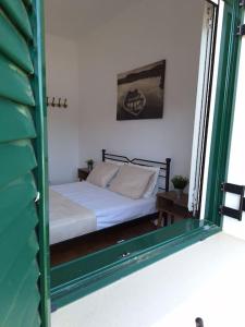 Ce lit se trouve dans un dortoir doté d'une fenêtre. dans l'établissement Cosy seaside house at Lagkada Chios, à Lagkáda