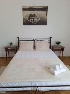 - un grand lit blanc avec des serviettes dans l'établissement Cosy seaside house at Lagkada Chios, à Lagkáda