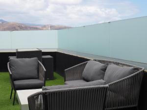 duas cadeiras e um sofá sentado num telhado em Ferienwohnung für 2 Personen ca 28 qm in Las Palmas de Gran Canaria, Gran Canaria Nordküste Gran Canaria em Las Palmas de Gran Canaria