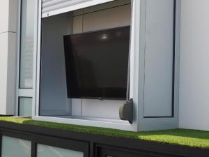 uma televisão de ecrã plano numa janela com relva verde em Ferienwohnung für 2 Personen ca 28 qm in Las Palmas de Gran Canaria, Gran Canaria Nordküste Gran Canaria em Las Palmas de Gran Canaria