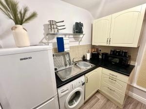 a small kitchen with a sink and a dishwasher at BOOT LANE STUDIO APARTMENT in Blaenavon