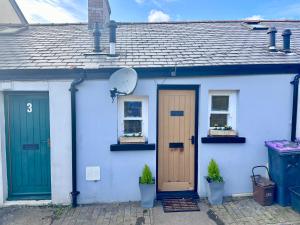a blue and white house with two doors and plants at BOOT LANE STUDIO APARTMENT in Blaenavon