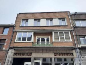 a tall brick building with windows on a street at LE PARADIS ATHOIS in Ath