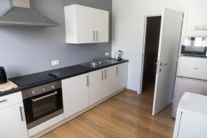 a kitchen with white cabinets and a sink at LE PARADIS ATHOIS in Ath