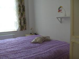 1 cama en un dormitorio con manta morada en Ferienwohnung für 5 Personen 1 Kind ca 115 qm in Bad Wilsnack, Brandenburg Landkreis Prignitz, 