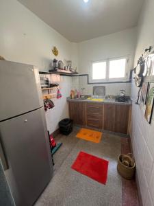 een keuken met een koelkast en een rood tapijt op de vloer bij Youss Appartement in Essaouira