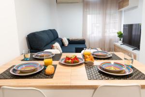 a table with plates of food on it in a living room at Apartamento 'Koala21', Nuevo, Céntrico y con opción de parking in Jaén