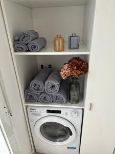 een wasruimte met een wasmachine en handdoeken bij Apartamento 'Koala21', Nuevo, Céntrico y con opción de parking in Jaén