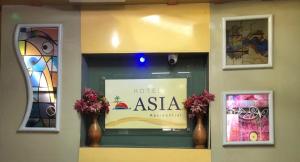 Un cartel de Hotel Asia en una ventana con jarrones. en Hotel Asia, en Cox's Bazar