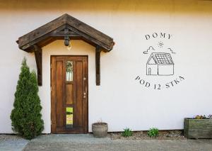 a house with a door and a sign on the wall at Domy pod 12-stką in Mrągowo