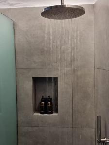 a chandelier with two bottles on a shelf in a bathroom at Màrgaros House Tinos in Triandáros