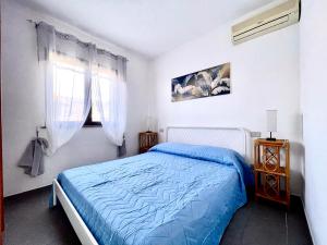 a bedroom with a blue bed and a window at Casa Porto San Rocco in Marina di Grosseto