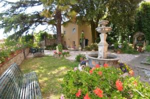 un jardín con una fuente y flores en un patio en Ferienhaus mit Privatpool für 4 Personen ca 70 qm in San Gennaro, Toskana Provinz Lucca, en San Gennaro