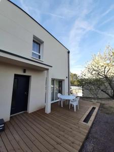 una terrazza in legno con panchina bianca su una casa di Maison neuve tout équipée a Tourville-sur-Odon