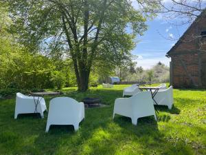 een groep witte stoelen en tafels in het gras bij Pfarrhaus Karbow in Hof Karbow