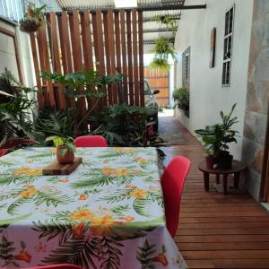 - une table avec un tissu de table floral sur la terrasse dans l'établissement Hojas Verdes Rental House Excelente ubicación cerca de Campo Ferial Palmares, à Palmares