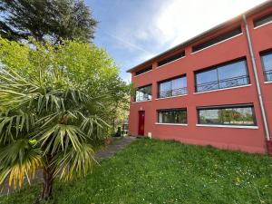 een rood gebouw met een palmboom ervoor bij Sweet Home LR in Le Raincy