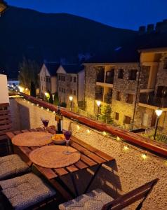 2 mesas con copas de vino en un balcón por la noche en ESQUÍ PIRINEO ARAGONÉS APARTAMENTO EL JUNCARAL Wifi, en Villanúa