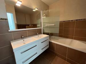een badkamer met een wastafel, een bad en een spiegel bij Sweet Home LR in Le Raincy +12 foto's