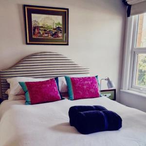 LincolnshireにあるStamford 2 bed character houseのベッドルーム1室(ピンクとブルーの枕が付いた白いベッド1台付)