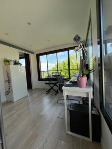 een woonkamer met een bureau en een groot raam bij Sweet Home LR in Le Raincy