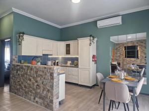 KORZO SUITES SENGLEA WATERFRONT في سنجليا: مطبخ بجدران زرقاء وطاولة مع كراسي