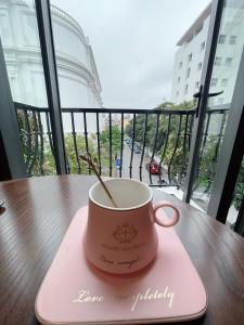 eine Tasse Kaffee auf einer rosa Serviette auf einem Tisch in der Unterkunft HOÀNG GIA HOTEL in Móng Cái
