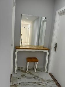 a bathroom with a mirror and a stool at Suite Rana Hedhun in Shëngjin