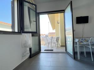 uma porta de vidro deslizante que leva a um pátio com uma mesa em Casa Porto San Rocco em Marina di Grosseto