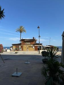 un edificio en la playa con palmeras y gente en SOLGUEST Apt ESTEPONA CENTRO 1ª LINEA DE PLAYA, en Estepona