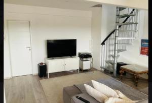 a living room with a couch and a flat screen tv at Loft Düsseldorf City in Düsseldorf