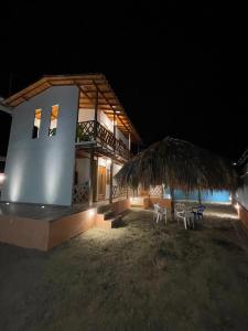 une maison avec 2 chaises et une terrasse couverte la nuit dans l'établissement Cabaña El Cangrejo Azul - Blue Crab House, à San Onofre