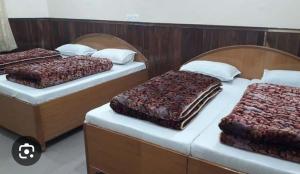 two twin beds in a room with two at OM Kutir Badrinath Dham in Badrīnāth