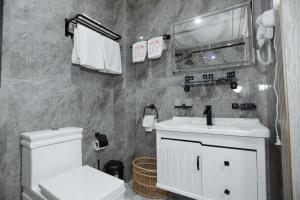 La salle de bains est pourvue d'un lavabo blanc et de toilettes. dans l'établissement "Bo'gishamol Gavhari" ООО, à Andijan