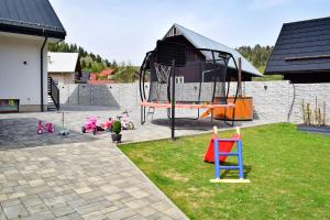 un patio con parque infantil y equipo de juegos en Chalupa Martinček, en Terchová