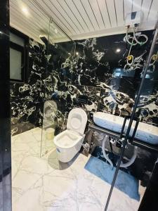 a bathroom with a toilet and a black and white wall at sea view apartment in Juhu in Mumbai