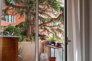 una puerta corredera de cristal con plantas en una mesa exterior en ophelia apartment, en Roma